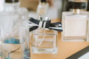 Detailní záběr na elegantní lahvičky parfému se zaměřením na jednu se stuhou.