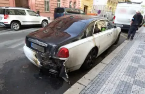 Ohořelý Rolls-Royce Ghost v ulici Na Valentince na pražském Smíchově